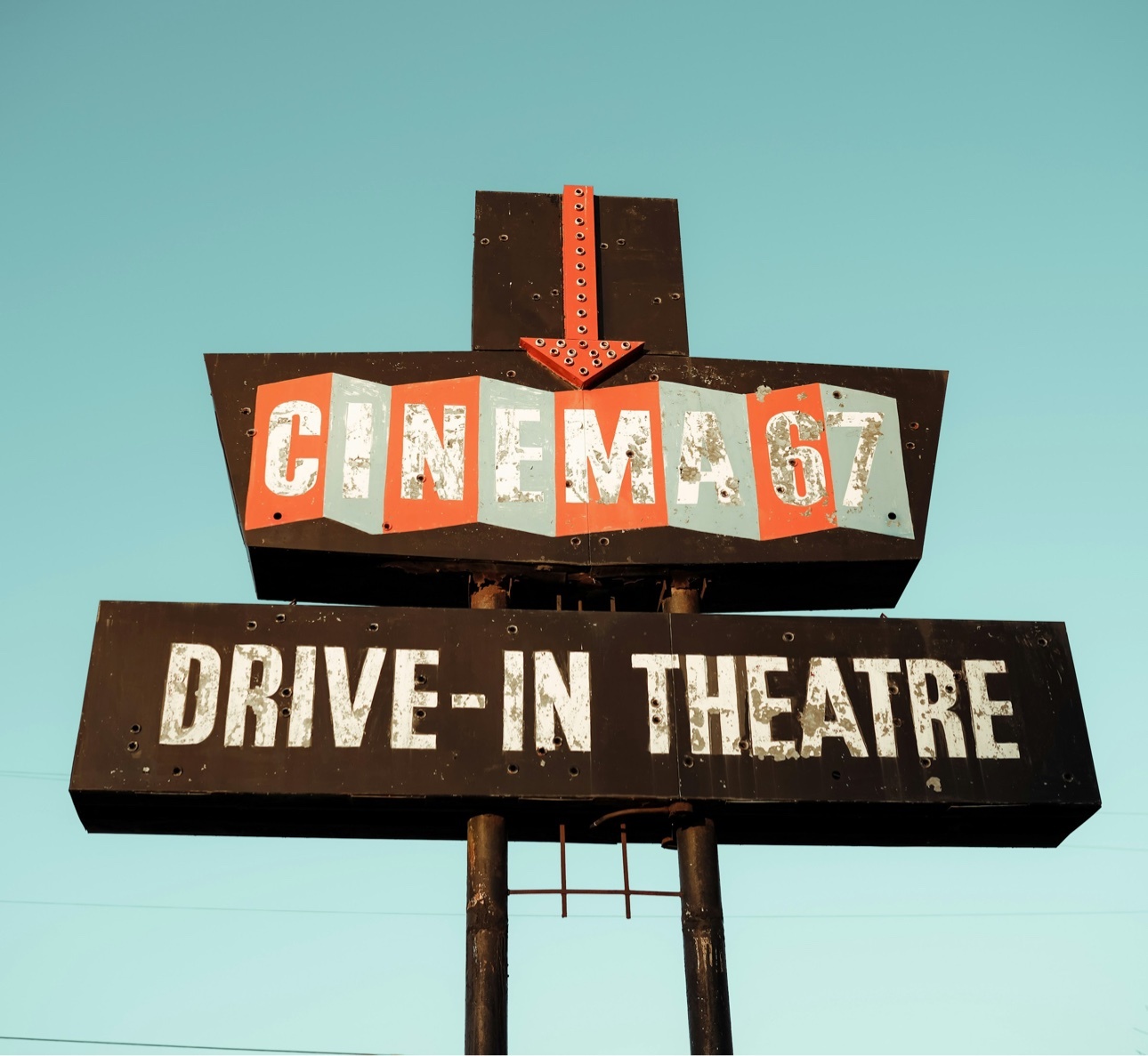 Drive-in theater sign against the sky, photographed by Dominique Hicks.